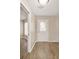 Bright entryway featuring a decorative glass front door and wood-look flooring that extends into the adjacent living spaces at 17159 Se 78Th Crowfield Ave, The Villages, FL 32162