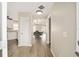 Inviting entryway showcasing wood floors, leading to kitchen and dining area with modern light fixture and open floor plan at 17159 Se 78Th Crowfield Ave, The Villages, FL 32162