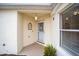 Front door entrance with light fixture and small potted plant at 17159 Se 78Th Crowfield Ave, The Villages, FL 32162