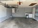 This is a spacious garage with a gray interior that includes a laundry area and a storage rack at 17159 Se 78Th Crowfield Ave, The Villages, FL 32162