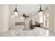 Spacious kitchen featuring granite countertops, pendant lighting, white cabinetry, stainless steel appliances, and modern fixtures at 17159 Se 78Th Crowfield Ave, The Villages, FL 32162