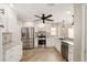 Well-lit kitchen boasts granite counters, stainless steel appliances, white cabinets, and a convenient ceiling fan at 17159 Se 78Th Crowfield Ave, The Villages, FL 32162