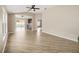 Spacious living room with wood floors, vaulted ceilings, neutral paint, and access to both the kitchen and pool area at 17159 Se 78Th Crowfield Ave, The Villages, FL 32162