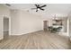 Open-concept living area with dining space, wood floors, neutral tones, and a view into the kitchen area at 17159 Se 78Th Crowfield Ave, The Villages, FL 32162