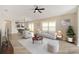 Bright living room featuring neutral tones, wood floors, a ceiling fan, and large windows that offer plenty of natural light at 17159 Se 78Th Crowfield Ave, The Villages, FL 32162