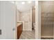 En-suite bathroom featuring a vanity with granite countertop, a step-in shower, and a walk-in closet with shelving at 17159 Se 78Th Crowfield Ave, The Villages, FL 32162