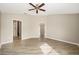 Primary bedroom boasting neutral tones, wood floors, and doorways leading to the bathroom and other areas at 17159 Se 78Th Crowfield Ave, The Villages, FL 32162
