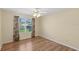 Bedroom with hardwood floors, a window with curtains, and beige colored walls at 17848 Se 87Th Bourne Ave, The Villages, FL 32162