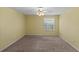 Empty bedroom with a ceiling fan, neutral walls, carpet flooring, and a window providing natural light at 17848 Se 87Th Bourne Ave, The Villages, FL 32162