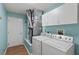 Functional laundry room with washer, dryer, utility sink, and storage cabinets at 17848 Se 87Th Bourne Ave, The Villages, FL 32162