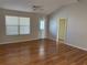 Bright living room with light walls, wood floors, a ceiling fan, and a large window for natural light at 17848 Se 87Th Bourne Ave, The Villages, FL 32162