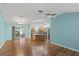 Open-concept living room featuring hardwood floors, aqua colored walls, and a kitchen island at 17848 Se 87Th Bourne Ave, The Villages, FL 32162