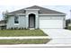 Charming single Gathering home featuring a two car garage, neutral paint, manicured lawn, and simple landscaping at 2827 Supermarine Rd, Tavares, FL 32778