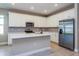 Bright kitchen with white cabinets, stainless steel appliances, an island, and a gray backsplash at 2878 Supermarine Rd, Tavares, FL 32778