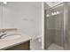 Modern bathroom featuring dual sinks, stone countertops, and a glass-enclosed shower at 2884 Supermarine Rd, Tavares, FL 32778