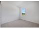 Bright bedroom featuring neutral carpet and a window with outside view at 2884 Supermarine Rd, Tavares, FL 32778