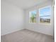 Bright bedroom featuring neutral carpet and two windows with outside view at 2884 Supermarine Rd, Tavares, FL 32778