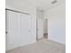 This bedroom boasts a closet with bi-fold doors and neutral carpeting at 2884 Supermarine Rd, Tavares, FL 32778