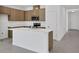 Kitchen boasts wood cabinets, an island with white countertops and stainless steel appliances at 2884 Supermarine Rd, Tavares, FL 32778