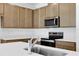 Bright kitchen features wooden cabinets, stainless steel appliances, and white quartz countertops at 2884 Supermarine Rd, Tavares, FL 32778