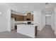 Open concept kitchen with an island, white countertops, wooden cabinets and stainless appliances at 2884 Supermarine Rd, Tavares, FL 32778
