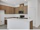 Kitchen with wood cabinets, an island with white countertop and stainless steel appliances at 2884 Supermarine Rd, Tavares, FL 32778