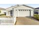 Front view of a white house with a garage and small yard at 2907 Barboza Dr, The Villages, FL 32162