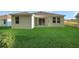 Backyard features a covered patio and views of the green grass and trees for ideal outdoor living at 2992 Supermarine Rd, Tavares, FL 32778