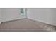 Carpeted bedroom bathed in light, with a window adding a touch of charm at 2992 Supermarine Rd, Tavares, FL 32778