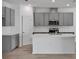 Modern kitchen with gray cabinetry, stainless steel appliances, and a central island with a sink at 2992 Supermarine Rd, Tavares, FL 32778
