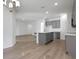 Open-concept kitchen with gray cabinets, white countertops, stainless steel appliances, and ample lighting at 2992 Supermarine Rd, Tavares, FL 32778