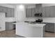 Modern kitchen featuring gray cabinets, stainless steel appliances, white countertops, and island sink at 2992 Supermarine Rd, Tavares, FL 32778
