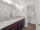 Modern bathroom featuring double sinks, a large mirror, wood cabinets, and a glass-enclosed shower at 320 Zingale Ln, The Villages, FL 32163
