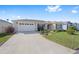 Well-maintained home featuring a spacious driveway, landscaping, and two-car garage at 320 Zingale Ln, The Villages, FL 32163