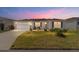 Charming home featuring a well-manicured lawn, landscaping, and two-car garage at 320 Zingale Ln, The Villages, FL 32163