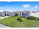 Well-maintained home featuring a manicured lawn and mature landscaping at 320 Zingale Ln, The Villages, FL 32163