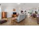 Spacious living room with wood flooring, a comfortable sofa, and an open layout leading to the kitchen at 320 Zingale Ln, The Villages, FL 32163