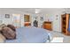 Comfortable bedroom showcasing a large bed, carpeted floors, ceiling fan, and a view into the ensuite bathroom at 320 Zingale Ln, The Villages, FL 32163