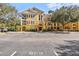 Three-story yellow building with balconies, lush landscaping, and ample parking at 3615 Conroy Rd # 614, Orlando, FL 32839