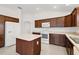 Kitchen boasts dark wood cabinets, an island, and modern appliances at 4056 Venetian Ln, The Villages, FL 32163