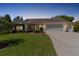 Lovely single-story home with a three-car garage and landscaped yard at dusk at 546 Foxfield Path, The Villages, FL 32162