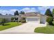 Charming single-story house with a three-car garage and lush green lawn at 546 Foxfield Path, The Villages, FL 32162
