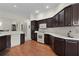 Bright kitchen featuring white appliances and dark wood cabinets at 546 Foxfield Path, The Villages, FL 32162