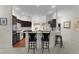 Open kitchen featuring dark cabinetry, modern appliances, and a breakfast bar with seating, perfect for casual dining at 546 Foxfield Path, The Villages, FL 32162