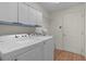 The laundry room features new washer/dryer and ample cabinet space at 546 Foxfield Path, The Villages, FL 32162