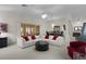 Bright, open living room with a plush seating area and sliding glass doors to an enclosed outdoor area at 546 Foxfield Path, The Villages, FL 32162