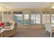 Bright sunroom features lots of windows, neutral decor, and comfortable seating at 546 Foxfield Path, The Villages, FL 32162