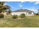 Landscaped backyard with lush grass and tropical plants at 603 San Pedro Dr, Lady Lake, FL 32159