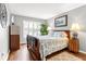 Bright bedroom with shuttered window, wooden floors, and a patterned quilt at 603 San Pedro Dr, Lady Lake, FL 32159