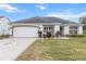 Charming single-story home with a well-manicured front lawn and a decorative driveway at 603 San Pedro Dr, Lady Lake, FL 32159
